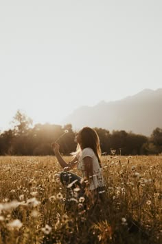 a woman sitting in the middle of a field