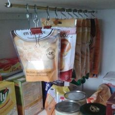 some food is sitting on the counter in front of boxes and bags hanging from hooks