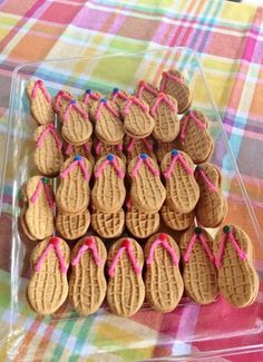 there are many cookies in the shape of flip flops with pink string on them