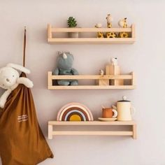 two wooden shelves with stuffed animals on them and a brown bag hanging from the wall