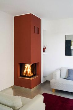 a living room filled with furniture and a fire place in the middle of the room