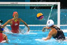 the water polo team is competing in an olympic game, with one player blocking the ball