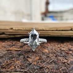 a diamond ring sitting on top of wood chips