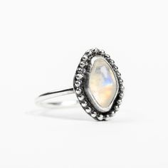 I handmade this beautiful natural Rainbow Moonstone gemstone ring from solid Sterling Silver. The gemstone has been surrounded by a beaded border. This ring looks great as a midi ring! Rainbow Moonstone is a variety of Labradorite, a member of the feldspar group, and features an iridescent sheen called "labradorescence." This means that the stone displays colors that change depending on the angle and source of the light striking the stone surface. In Rainbow Moonstone, this characteristic is due Bohemian Adjustable Moonstone Birthstone Ring, Bohemian Moonstone Crystal Ring With Birthstone, Bohemian Moonstone Crystal Ring With Natural Stones, Bohemian Stackable Moonstone Rings With Gemstones, Natural Stones Moonstone Open Ring, Bohemian Moonstone Moon-shaped Crystal Ring, Bohemian Moonstone Crystal Ring In Moon Shape, Bohemian Moonstone Crystal Ring With Gemstone, Natural Moonstone Open Ring