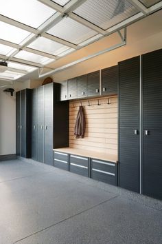 an empty garage with several cabinets and a coat rack