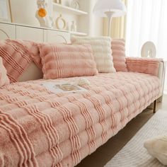 a bed with pink and white pillows on it