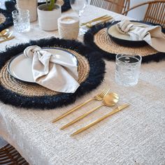 the table is set with plates, silverware and napkins