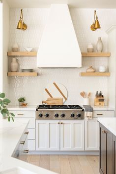 a stove top oven sitting inside of a kitchen next to wooden shelves and open shelving