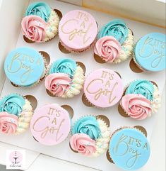 cupcakes decorated with pink, blue and white frosting are in a box