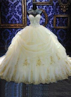 a wedding dress on display in front of a blue wall with gold trimmings