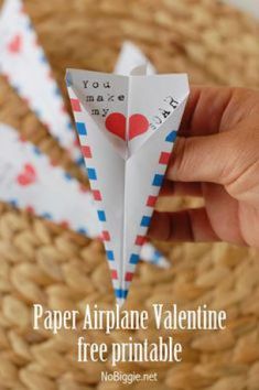 someone is holding an origami heart in their hand and it says paper airplane valentine free printable