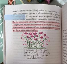 an open book with writing on it and flowers in the pages next to some crayons