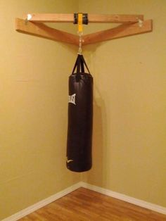 an empty room with a punching bag hanging on the wall and a pair of black boxing gloves