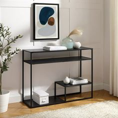 a black shelf with some books on it and a plant in the corner next to it