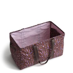 a brown and pink patterned bag on a white surface with straps around the inside of it