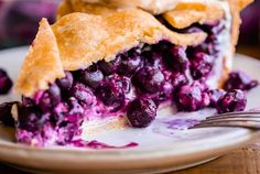 a slice of blueberry pie on a plate with a bite taken out of it