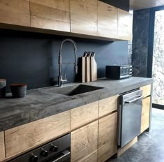 a kitchen with black walls and wooden cabinets