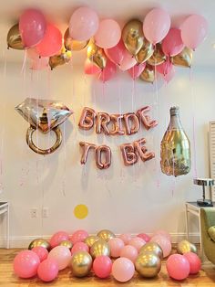 balloons and confetti are on the floor in front of a wall that says bride to be