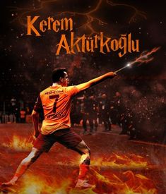 a soccer player is kicking the ball with his arms in the air and fire behind him