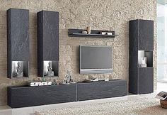 a modern living room with stone walls and black entertainment center, built in bookshelves