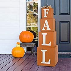 two pumpkins are sitting on the porch next to boxes that say fail and fall