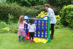 two girls and a girl standing in front of a giant connect - it - all game