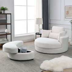 a living room with white furniture and rugs on the floor in front of a window