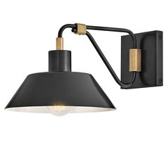 a black and gold wall light with a white bulb on the left side of it