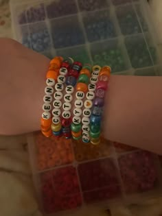 two bracelets with words on them sitting next to each other in front of a plastic container