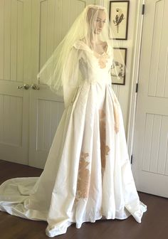 a wedding dress on display in front of a door