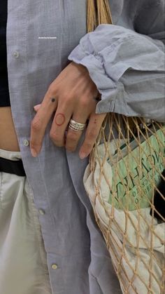 a person wearing a ring and holding a bag