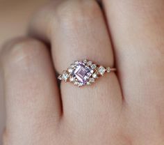 a woman's hand with a ring on it and an engagement ring in the middle