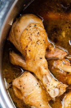 the chicken is cooking in the pot with broth and seasoning on it's side