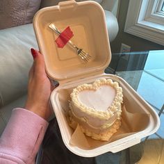 a heart shaped cake in a foam container with a fork sticking out of the top