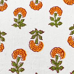 an orange and green flower pattern on white fabric