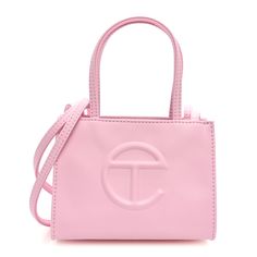 This is an authentic TELFAR Vegan Leather Small Shopping Bag in Bubblegum. This mini tote is constructed of faux leather in pink with the iconic raised Telfar logo at the front. The shoulder bag has thin pink handles and a long crossbody strap. The bag opens to a pink fabric interior. Telfar Logo, Pink Handles, Green Highlights, Orange Bag, Mini Tote, Pink Fabric, White Bag, Bubble Gum, Crossbody Strap