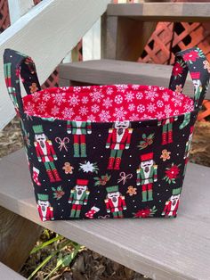 a christmas themed basket sitting on top of a wooden bench