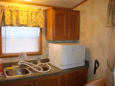 a kitchen area with sink, refrigerator and window