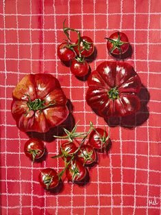 tomatoes are arranged on a red table cloth