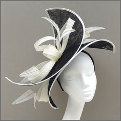 Stunning black and ivory double disc fascinator/hatinator layered at alternate angles. A unique design created with loops of sinamay and pretty arrow head feathers. A real stand out piece! Made on a headband. Ideal headpiece for Ladies Day, races or formal event. This design is available in other colours on request. All of our designs can be made to order in a range of different colours or styles, see our colour chart: https://jacquivaledesigns.co.uk/pages/sinamay-colour-chart Please contact us White High Crown Fascinator For Evening, White High Crown Adjustable Fascinator, White Fitted High Crown Fascinator, Adjustable Cream Top Hat For Formal Occasions, Cream Adjustable Top Hat For Formal Occasions, Formal Adjustable Cream Top Hat, Formal Fitted White Boater Hat, White Brimmed Top Hat For Evening Events, White Brimmed Top Hat For Evening