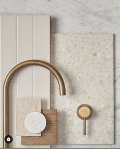 a bathroom with marble tiles and brass faucet on the wall next to a soap dispenser