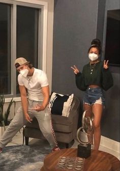 two people wearing masks in a living room