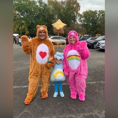 two adults and one child in costumes standing next to each other on a parking lot