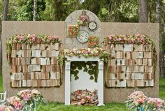 an outdoor fireplace with flowers on it and a clock mounted to the wall behind it