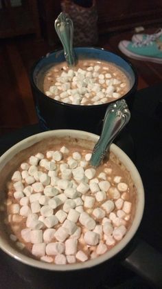 two bowls filled with marshmallows on top of a table