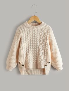 a white sweater hanging on a hanger with an image of a cable knit sweater