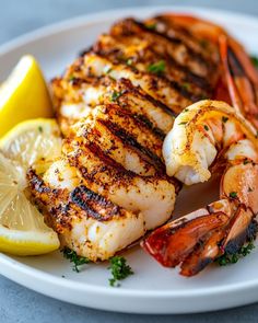 a white plate topped with shrimp and lemon wedges