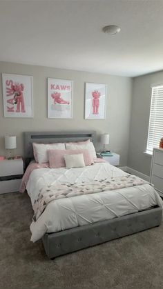 a bedroom with a bed, dresser and two pictures on the wall