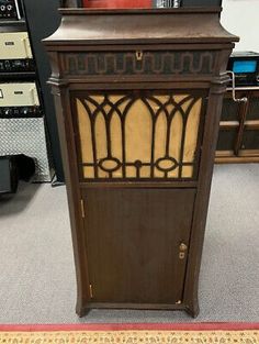 an old fashioned wooden cabinet with glass doors