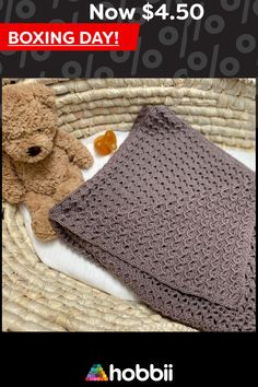 a brown teddy bear sitting next to a crocheted blanket on top of a wicker basket